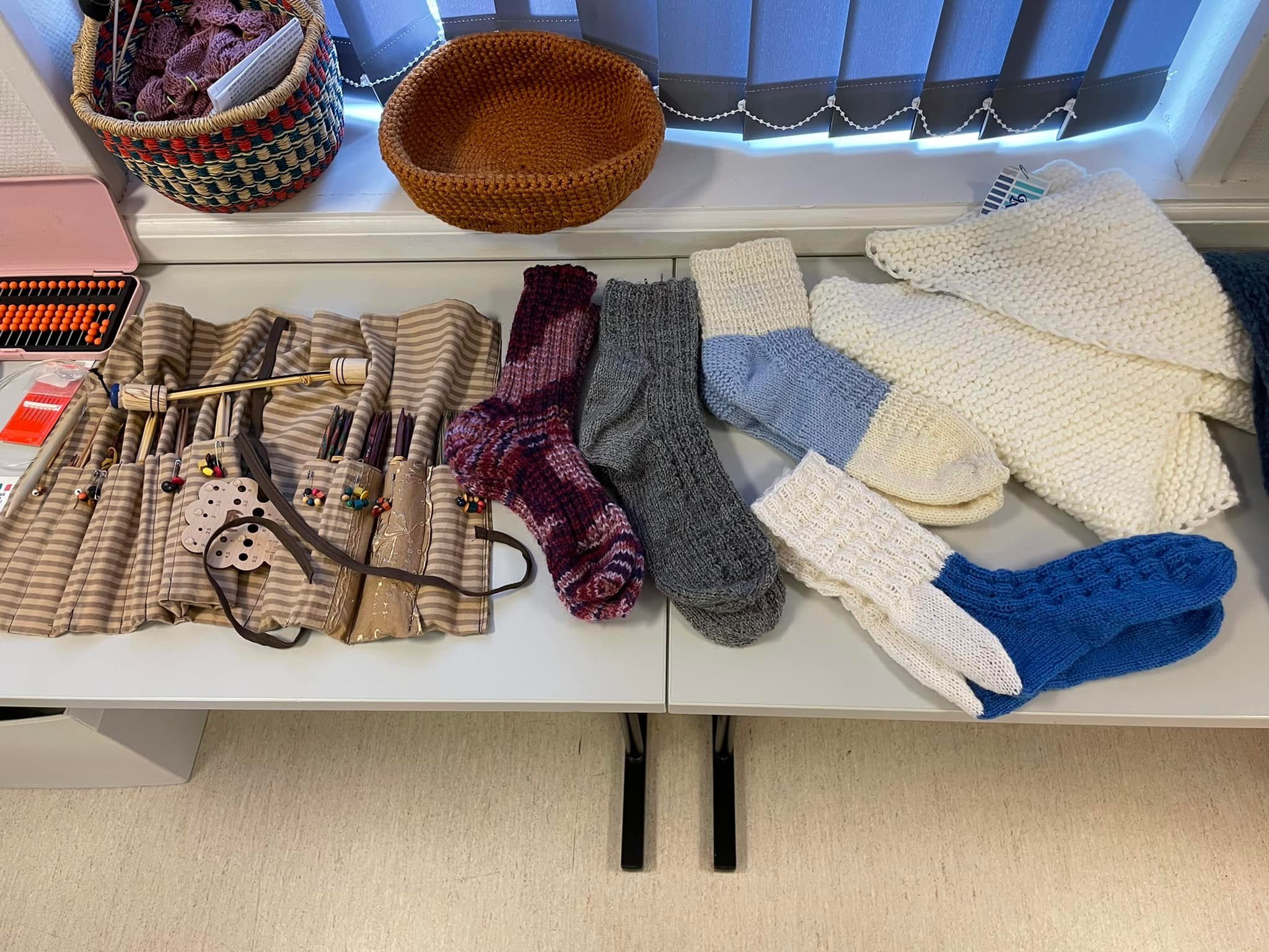 Mange forskjellige strikke-produkter på et bord.