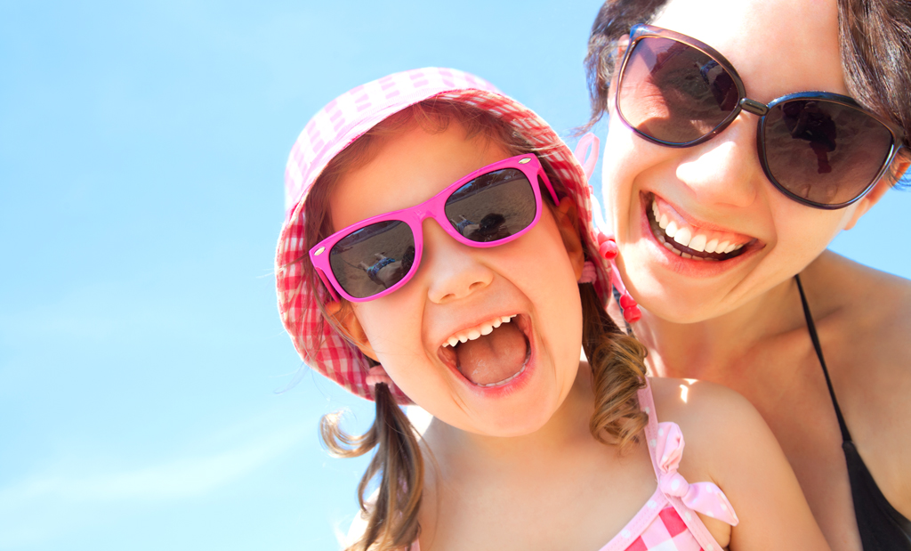 Solbriller er viktig både for store og små. Bilde av mor og datter med solbriller. Foto: Shutterstock