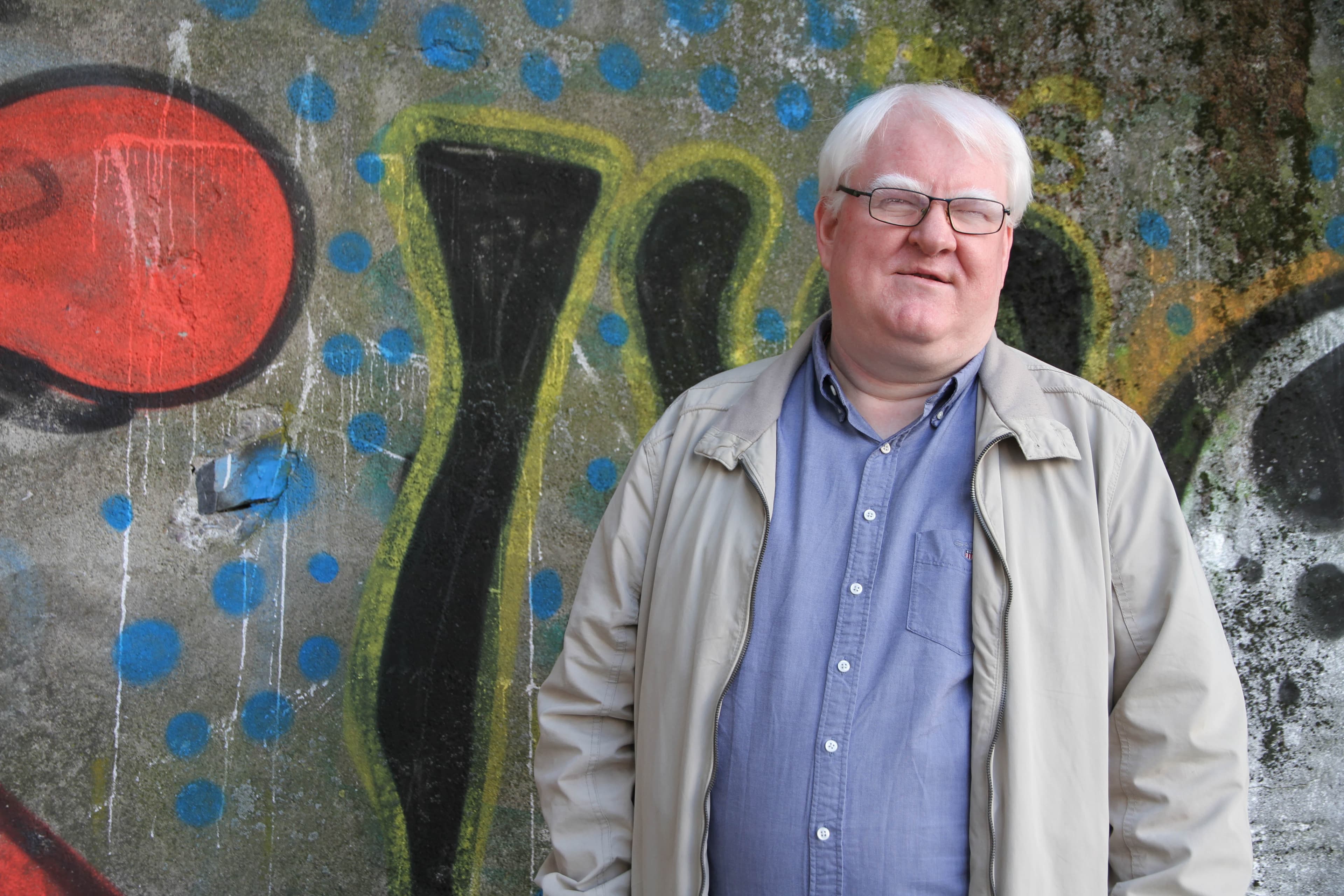Terje Andre Olsen foran en grafittivegg