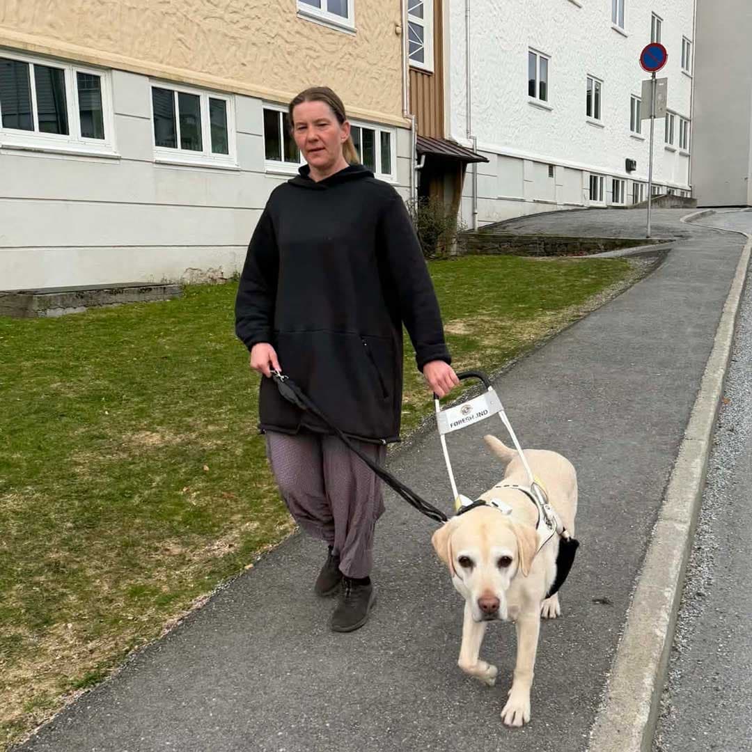 Lillann og Frost går på fortauet utenfor en boligblokk.