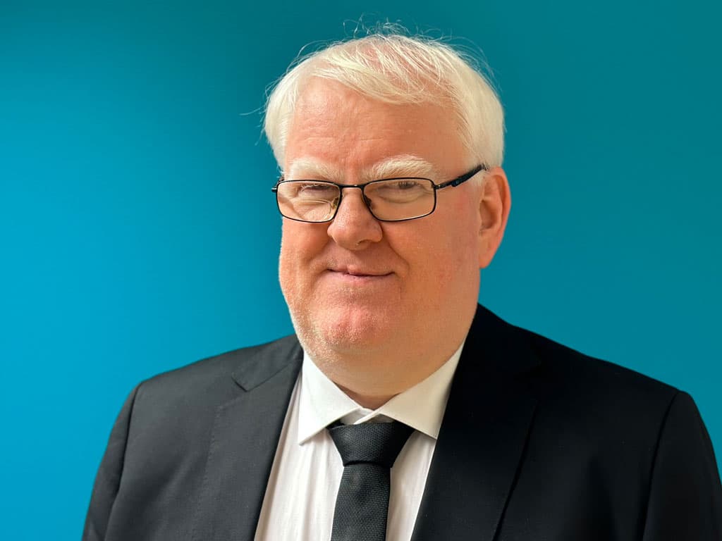 Portrettbilde av Olsen i mørk dress