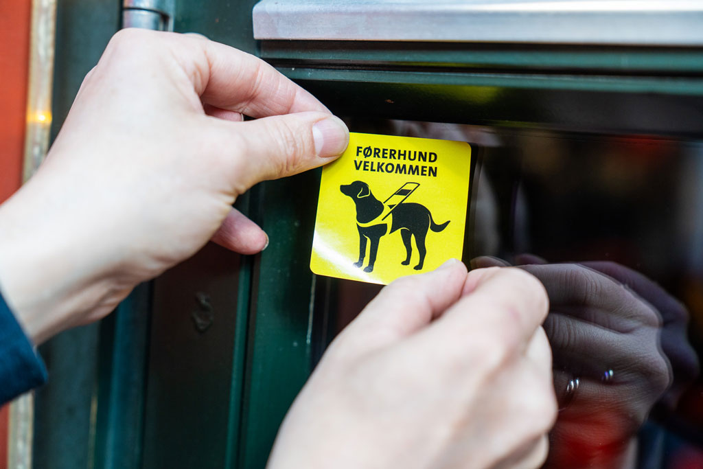 Et førerhund velkommen klistremerke på en dør